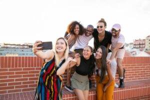 Photo by Kampus Production: https://www.pexels.com/photo/excited-young-diverse-men-and-women-taking-selfie-on-rooftop-5935228/