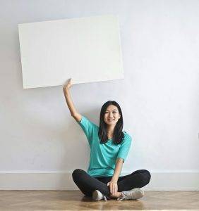 Photo by Andrea Piacquadio: https://www.pexels.com/photo/smiling-ethnic-woman-with-blank-poster-in-empty-flat-3758104/